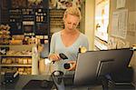 Young saleswoman scanning product in store