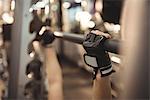 Hands of fit woman exercising with smith machine in the gym