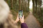 Woman clicking a picture in the forest