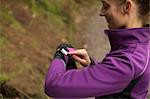 Beautiful woman using smart watch in the forest