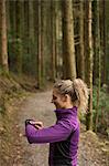 Beautiful woman using smart watch in the forest