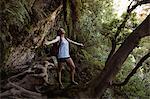 Carefree female hiker standing with her arms outstretched in the forest