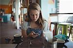 Woman using mobile phone in Café