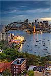 Cityscape image of Sydney, Australia with Harbour Bridge and Sydney skyline during twilight blue hour.