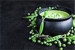 Green peas soup on dark wooden background. Low key photo. Copy space background.