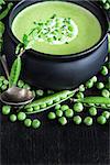 Green peas soup on dark wooden background. Low key photo. Copy space background.
