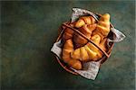 Freshly baked croissants on the dark green background with place for text. Selective focus, rustic style.