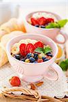 Porridge with banana and fresh berries in a cups. Healthy eating