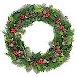 Christmas and winter wreath decoration with holly, mistletoe, juniper fir, blue spruce, cedar, pine cones and ivy leaves on white background.