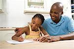 Young African father helping her daughter with her homework