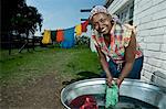 Black female hand washes clothing outside her rural home