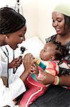 African mother and her two children sitting with a doctor for a consultation