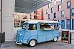 Vintage pizza van parked outside office buildings