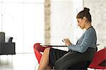 Businesswoman sitting in office looking at smartphone