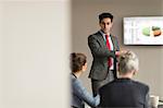 Over shoulder view of businessman making office presentation to colleagues