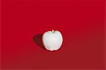 Apple painted white on red background