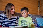 Childminder reading book with boy