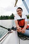 Woman on sailing boat, steering boat