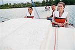 Three friends on sailing boat, on lake