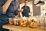 Chef filling plastic containers with portions of food