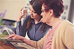 Young woman at table with grandmother looking at photo album