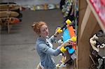 Woman working in skateboard shop, organising skateboard display