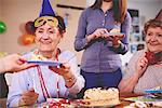 Senior women being served birthday cake at party