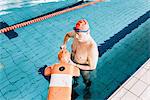 Senior man preparing lifesaving training equipment in swimming pool