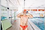 Senior man standing by swimming pool