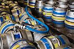 Close up of metal beer kegs being filled in a brewery.