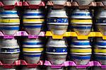 Close up of stacks of metal beer kegs in a brewery.