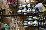 Directly above view of a man working in a brewery, metal beer kegs standing on the floor.