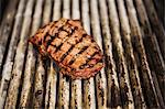 Close up high angle view of a steak on a griddle.