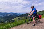 Man sitting on bicycle looking at mountains