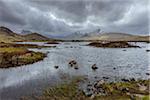 Moor landscape with a river and storm clouds at Rannoch Moor in Scotland, United Kingdom