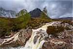 Waterfall on River Coupal and mountain range Buachaille Etive Mor in the background at Glen Coe in Scotland, United Kingdom