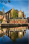 The Oude Kerk reflected in the Oudezijds Voorburgwal canal in the city center of Amsterdam, Holland