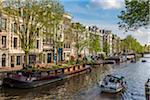 Houseboats and touring boats along the Keizersgracht canal in sprintime in Amsterdam, Holland