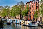 Typical buildings and houseboats moored along the Prinsengracht canal in Amsterdam, Holland