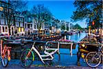 Bicycles parked along the Berensluis bridge at the Keizersgracht canal at dusk in Amsterdam, Holland