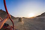 Personal perspective view of man's arm driving beach buggy in desert, Hurghada, Al Bahr al Ahmar, Egypt