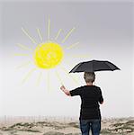 Senior woman with umbrella drawing sun in air