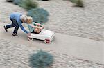 Grandmother pushing grandson on his toy car