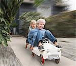 Grandson pushing grandmother on his toy car