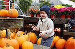Boy selecting pumpkin in garden centre