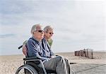 Senior man in wheelchair with wife at beach, Santa Monica, California, USA