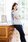 Portrait of female designer leaning against drawers in creative studio