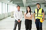 Portrait of three workers, standing in newly constructed office space