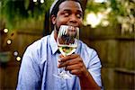 Mid adult man at garden party, holding glass of wine