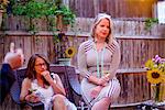 Two women at garden party, sitting, in conversation